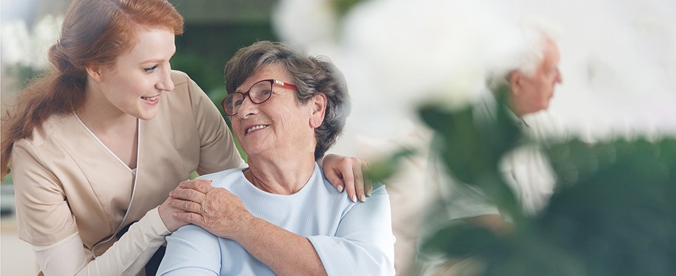 An image of a caregiver and senior woman talking
