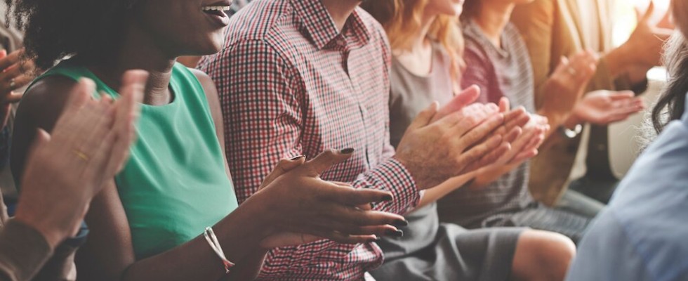 Image of people sitting down, clapping