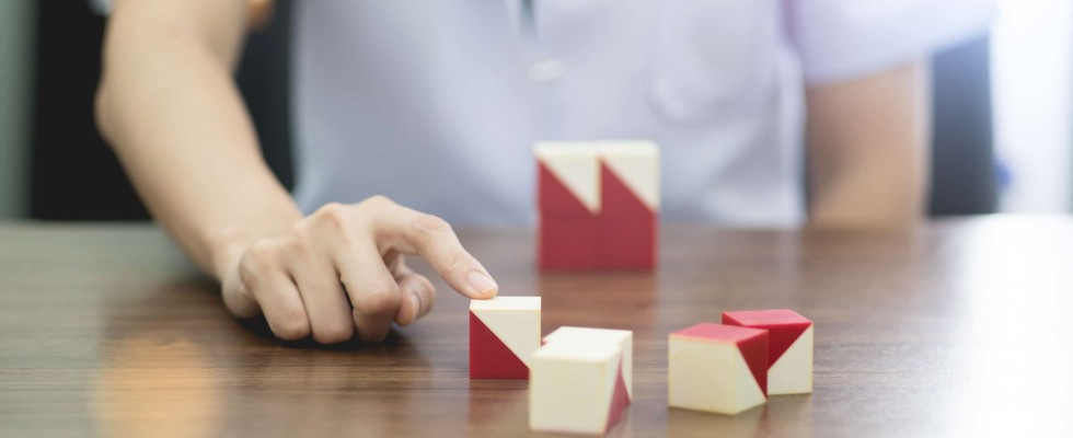 Person with finger on building blocks