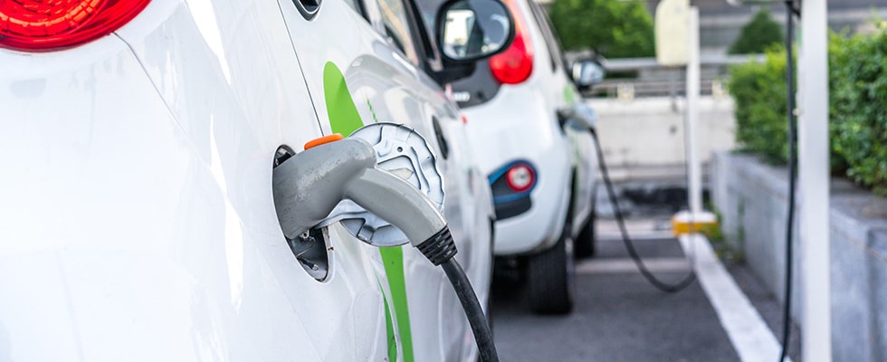 white crossover vehicles plugged in to chargers