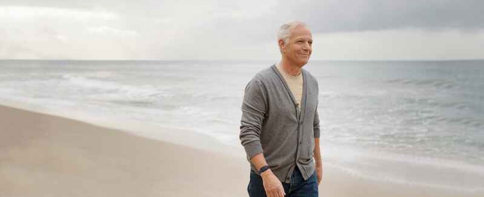 Elderly man walking on beach