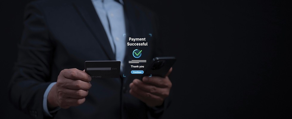 Man holding a card to a payment system, with a digital "payment successful" checkmark hovering above.