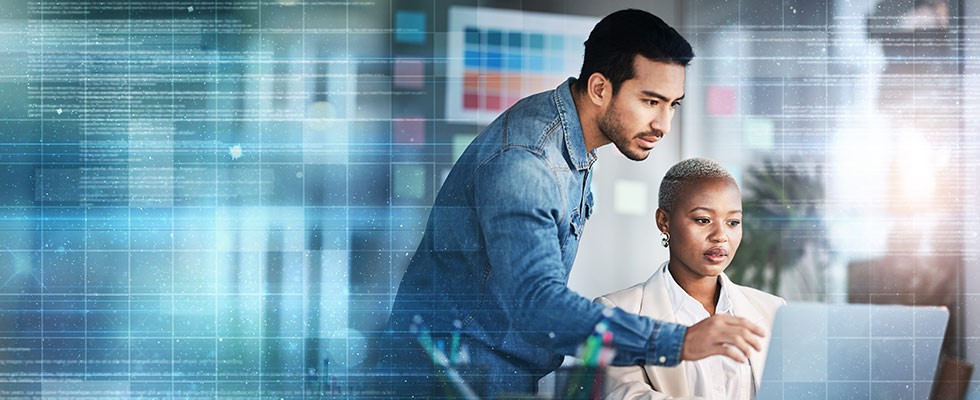 A man and a woman look at a computer screen