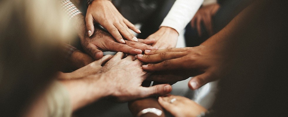 A group of people putting their hands in for a cheer