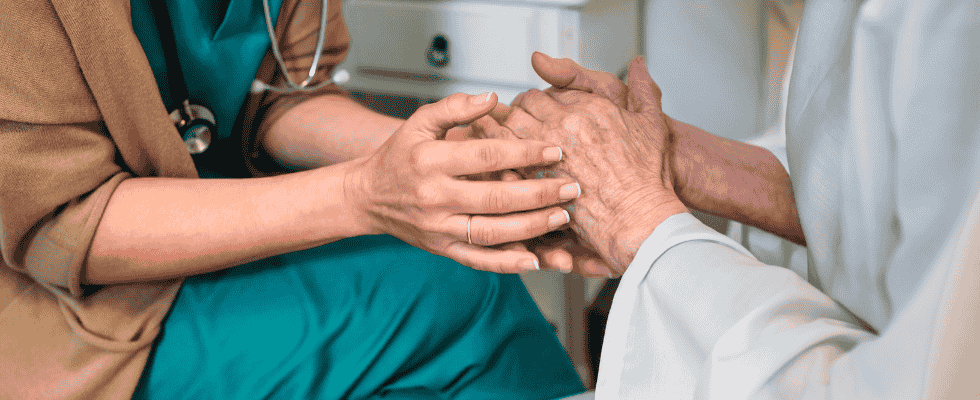 A caregiver holding hands with a patient