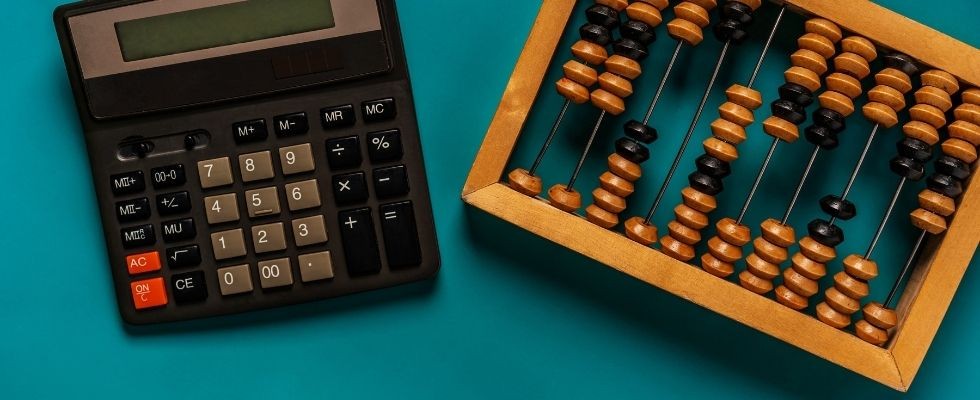 A calculator and an abacus on a teal background