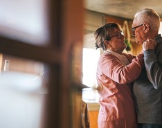 Older couple dancing in their home.