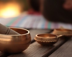 Wooden and copper bowls on a table outdoors, with people blurred out in the background.