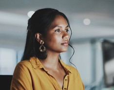 Woman looks at computer screen in an office.