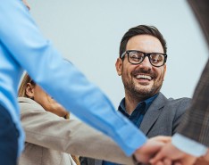 A group of people have their hands together for a group cheer. 