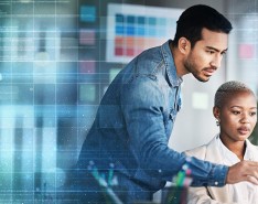 A man and a woman look at a computer screen