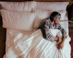 A man in a bed with a CPAP machine on sleeping
