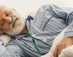 Man lying in bed while using oxygen equipment. 